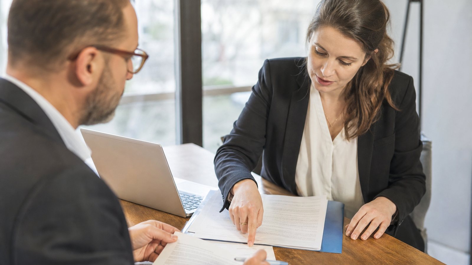 Responsable d'organisme de formation comparant plusieurs devis de certificateurs Qualiopi à son bureau